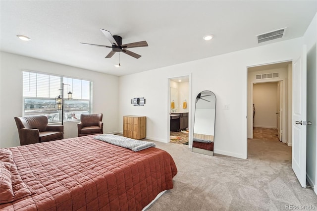 bedroom with light colored carpet, ceiling fan, and ensuite bath