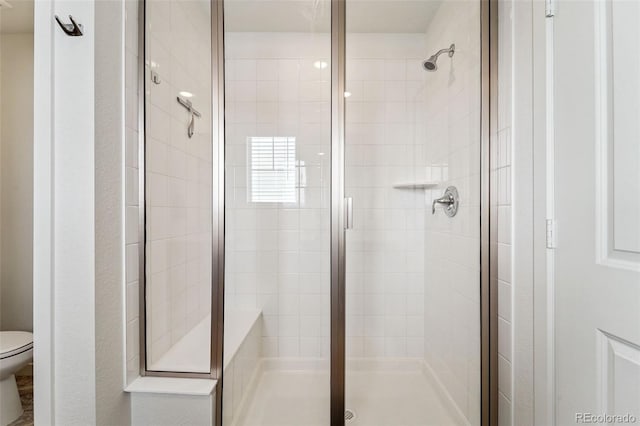 bathroom featuring toilet and an enclosed shower