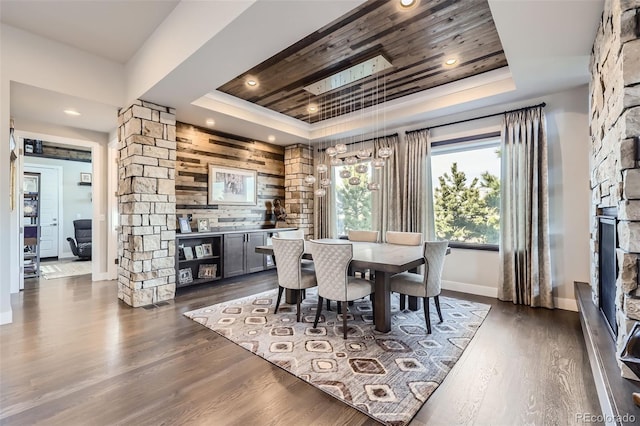 dining space featuring a raised ceiling and dark hardwood / wood-style floors