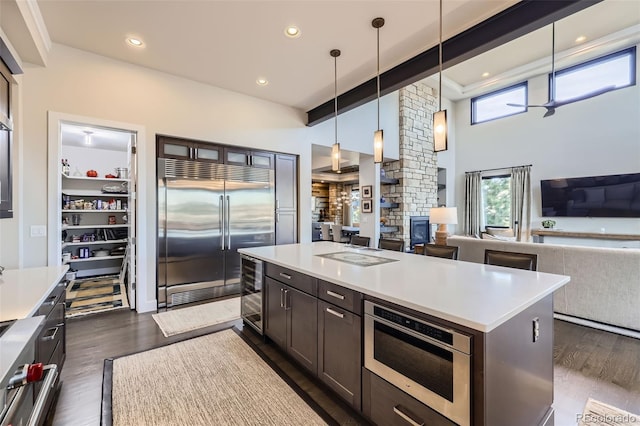 kitchen featuring built in fridge, dark wood-type flooring, pendant lighting, and a kitchen island