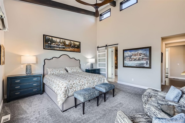 carpeted bedroom featuring connected bathroom, a towering ceiling, a barn door, ceiling fan, and beamed ceiling