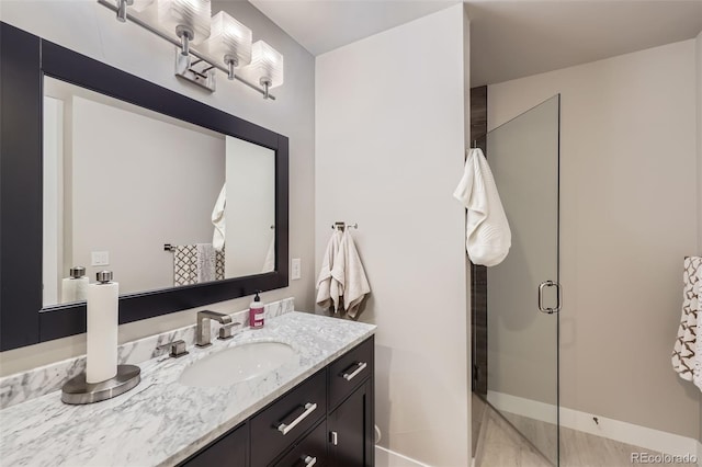 bathroom with a shower with door and vanity