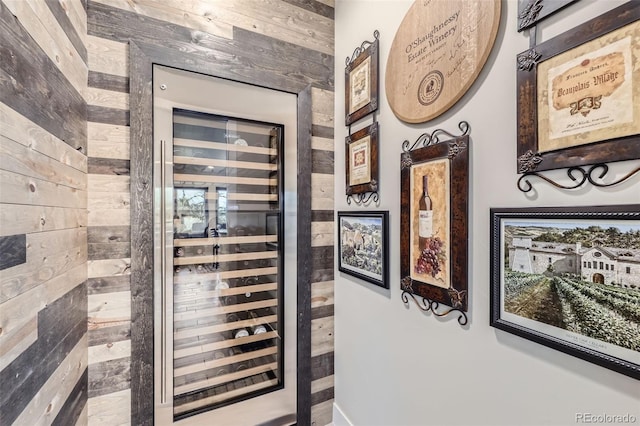 interior space featuring beverage cooler and wood walls