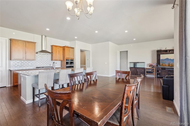 dining area featuring an inviting chandelier and dark hardwood / wood-style flooring