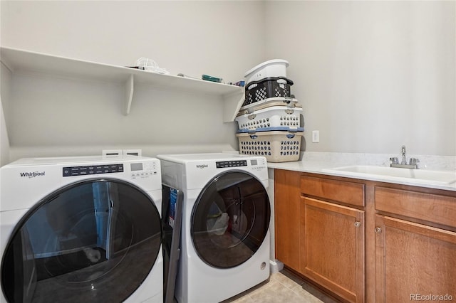 laundry room with cabinets, light tile patterned flooring, washer and clothes dryer, and sink