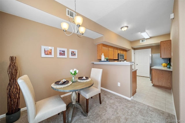 dining space with light colored carpet and a chandelier