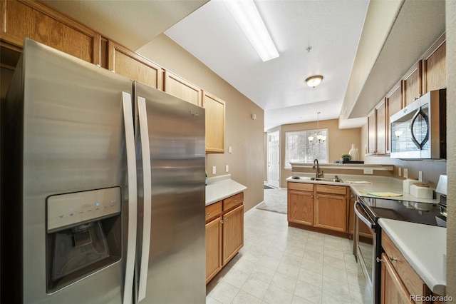 kitchen with appliances with stainless steel finishes, sink, kitchen peninsula, and decorative light fixtures