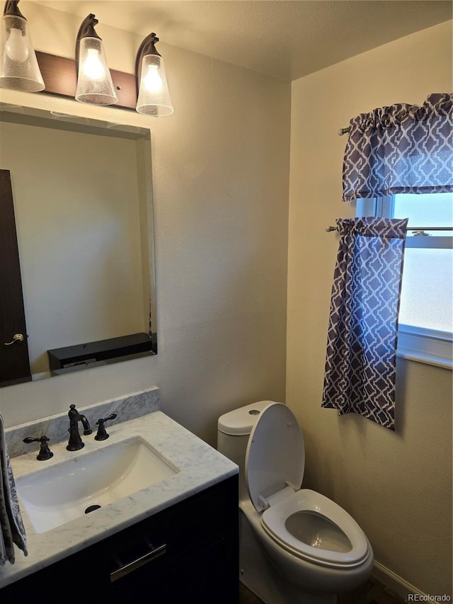 bathroom featuring vanity, toilet, and a textured ceiling