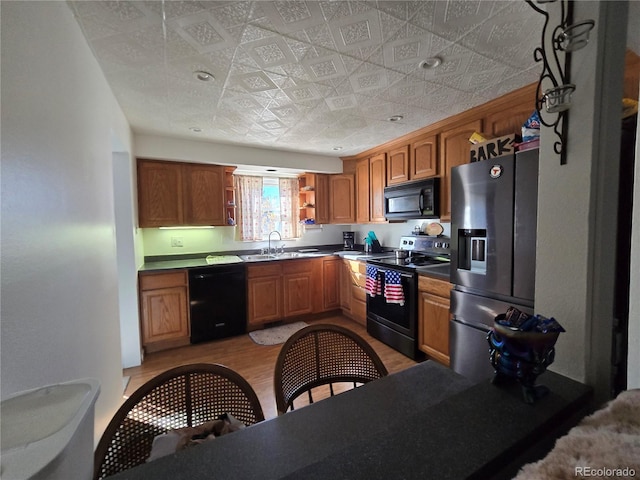 kitchen featuring black appliances, light hardwood / wood-style floors, and sink