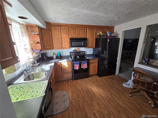 kitchen with black appliances, sink, and hardwood / wood-style floors