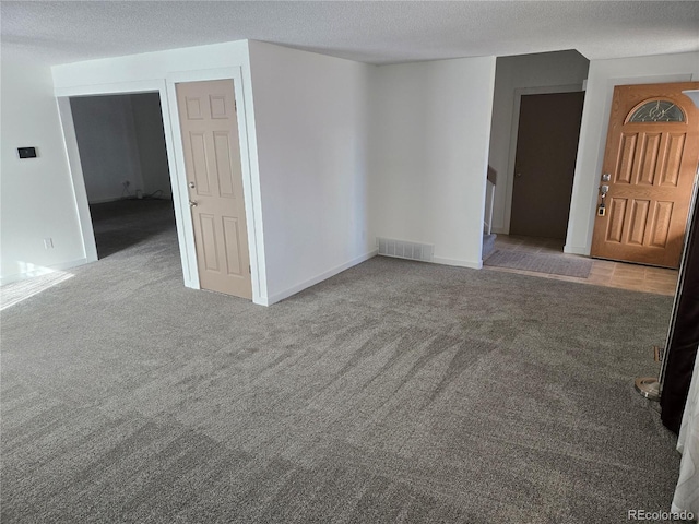 carpeted empty room featuring a textured ceiling