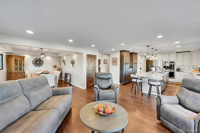 living room with light hardwood / wood-style flooring and sink