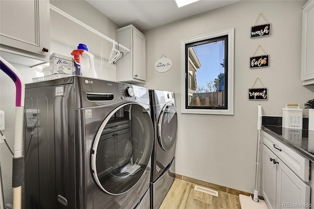 laundry room featuring cabinets and washing machine and dryer