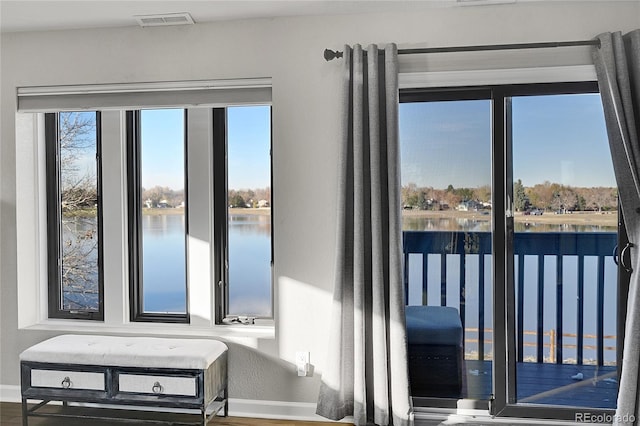 doorway to outside with wood-type flooring, a water view, and a wealth of natural light