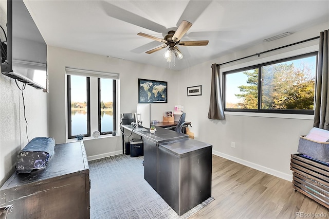 office area with ceiling fan, a healthy amount of sunlight, and light hardwood / wood-style floors