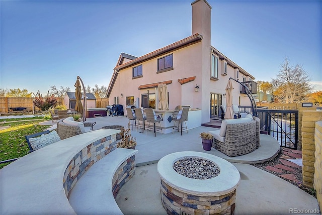 rear view of house featuring a patio area, exterior bar, and an outdoor fire pit