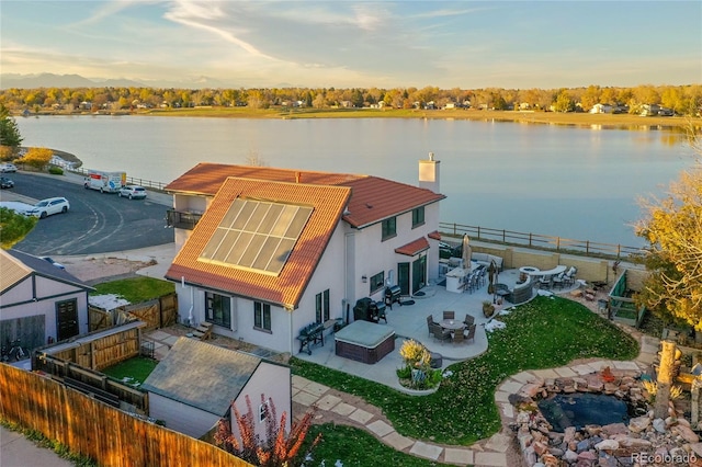 aerial view at dusk featuring a water view