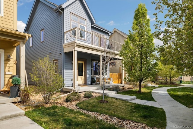 1702 W 66th Ave, Denver, CO 80221 - view of front of home with a porch, a balcony, and a front lawn