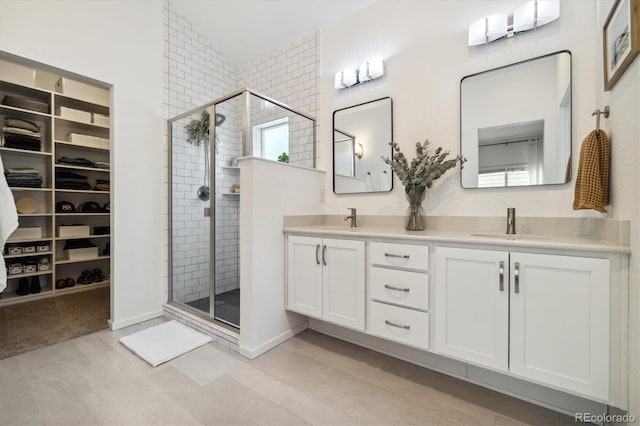1702 W 66th Ave, Denver, CO 80221 - bathroom featuring double vanity, a walk in closet, a sink, and a stall shower