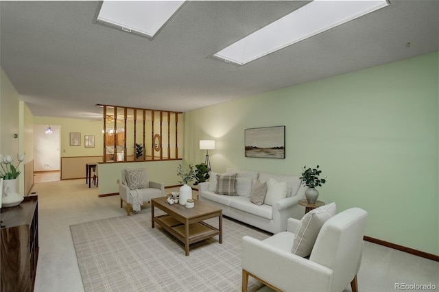 living room featuring light carpet, a skylight, and a textured ceiling