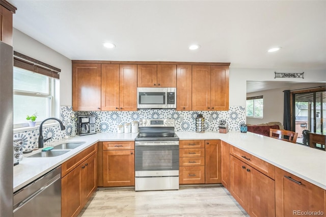 10462 Hoyt St, Westminster, CO 80021 - kitchen featuring stainless steel appliances, light countertops, tasteful backsplash, brown cabinetry, and recessed lighting
