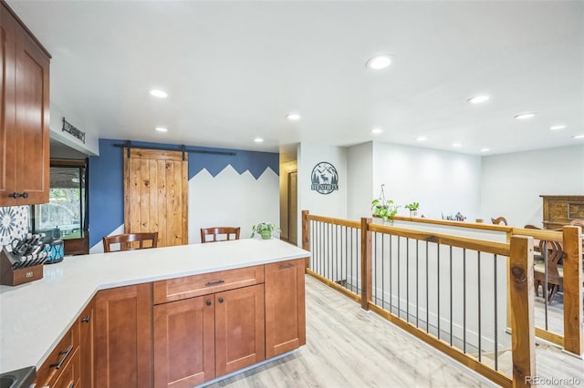 10462 Hoyt St, Westminster, CO 80021 - kitchen with a peninsula, a barn door, recessed lighting, light wood-style flooring, and light countertops