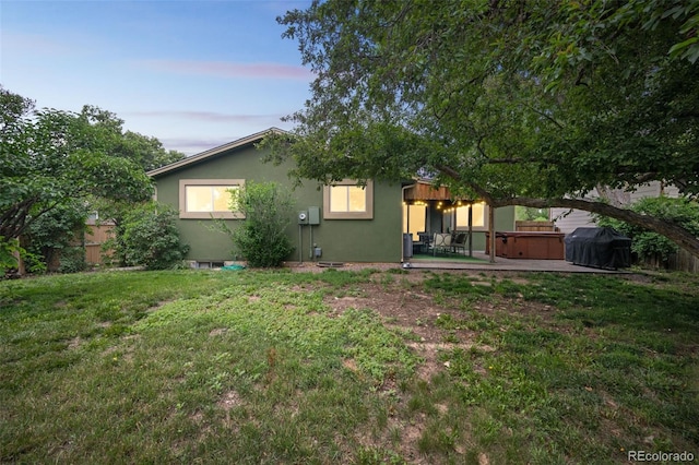 10462 Hoyt St, Westminster, CO 80021 - back of property at dusk featuring a hot tub, a patio, and stucco siding