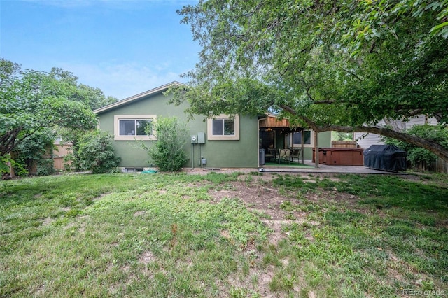 10462 Hoyt St, Westminster, CO 80021 - rear view of property featuring a hot tub, a patio, a lawn, and stucco siding