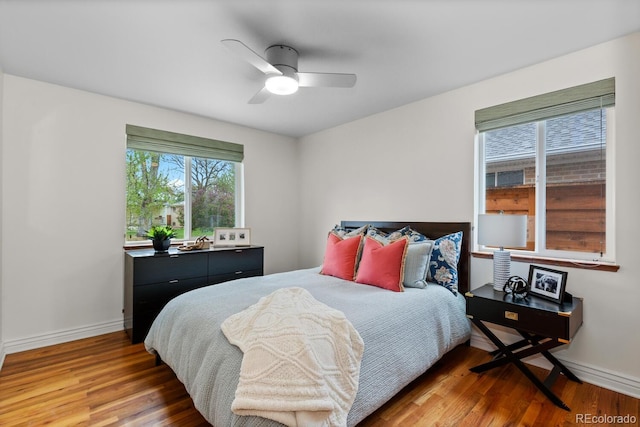 bedroom with wood finished floors, baseboards, and a ceiling fan