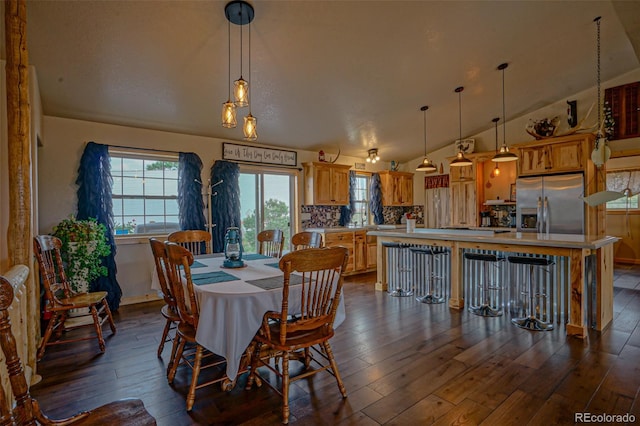 dining space featuring wood-type flooring and vaulted ceiling