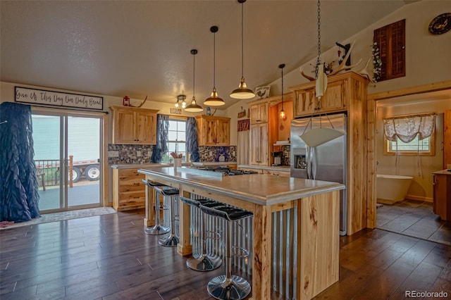 kitchen with vaulted ceiling, decorative light fixtures, a kitchen island, decorative backsplash, and dark hardwood / wood-style floors