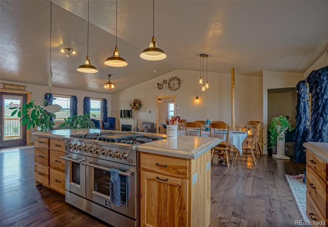 kitchen featuring a center island, dark hardwood / wood-style flooring, hanging light fixtures, range with two ovens, and vaulted ceiling