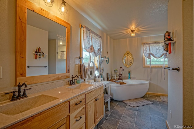 bathroom with tile patterned flooring, a bathtub, dual bowl vanity, and a textured ceiling