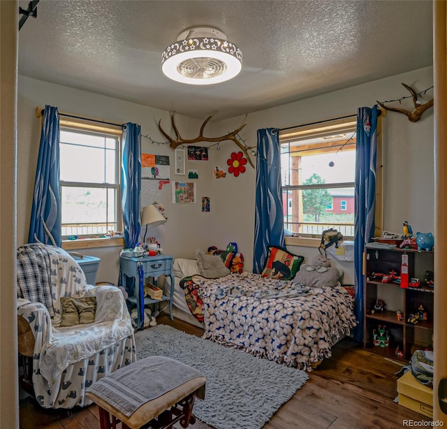 bedroom with hardwood / wood-style flooring and a textured ceiling