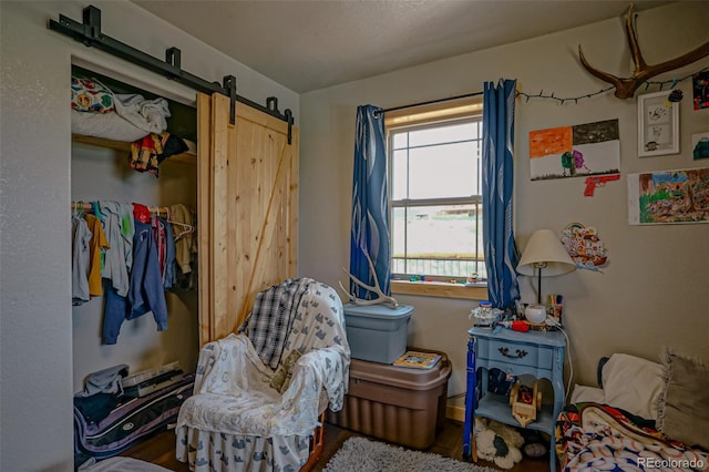 bedroom featuring hardwood / wood-style floors and a barn door