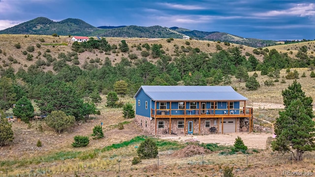 back of property with a mountain view and a garage