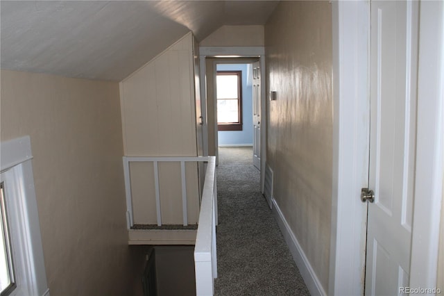 hall featuring dark colored carpet and lofted ceiling