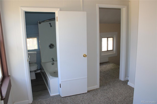 bathroom with plenty of natural light, bathtub / shower combination, and toilet