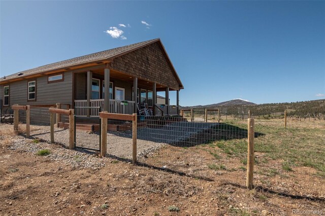 526 Wagon Wheel Rd, Hartsel, CO 80449 - back of house featuring covered porch, a fenced front yard, and a mountain view