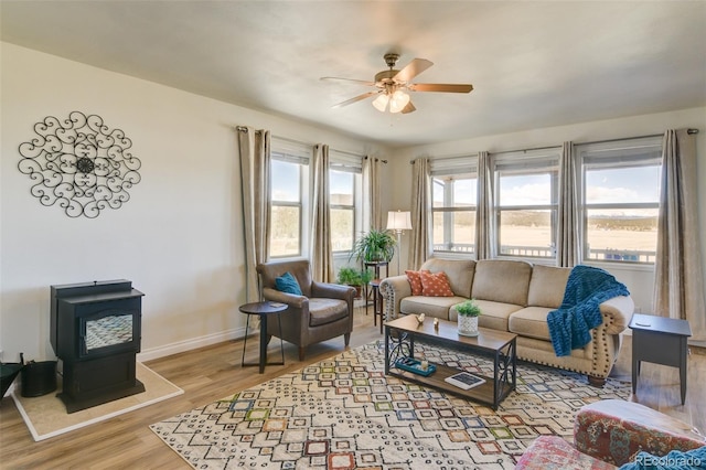 526 Wagon Wheel Rd, Hartsel, CO 80449 - living area featuring a ceiling fan, a wood stove, wood finished floors, and baseboards