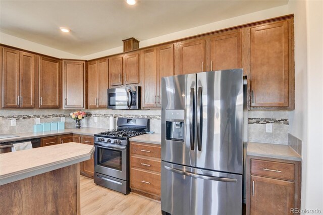 526 Wagon Wheel Rd, Hartsel, CO 80449 - kitchen featuring stainless steel appliances, backsplash, light countertops, brown cabinetry, and light wood finished floors