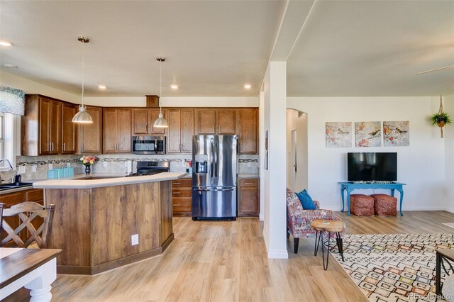 526 Wagon Wheel Rd, Hartsel, CO 80449 - kitchen with stainless steel appliances, light wood-style flooring, arched walkways, tasteful backsplash, and recessed lighting