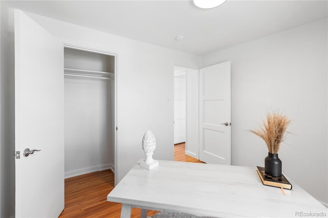 home office with light wood-type flooring and baseboards