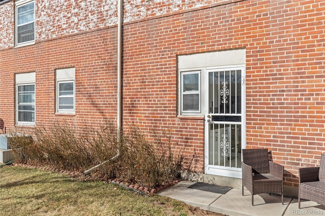 view of exterior entry featuring brick siding