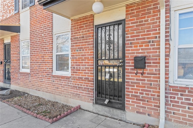 doorway to property with brick siding