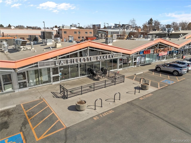 view of home's community with fence and uncovered parking