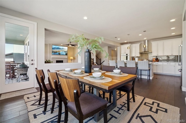 dining space with dark wood finished floors, recessed lighting, and a fireplace