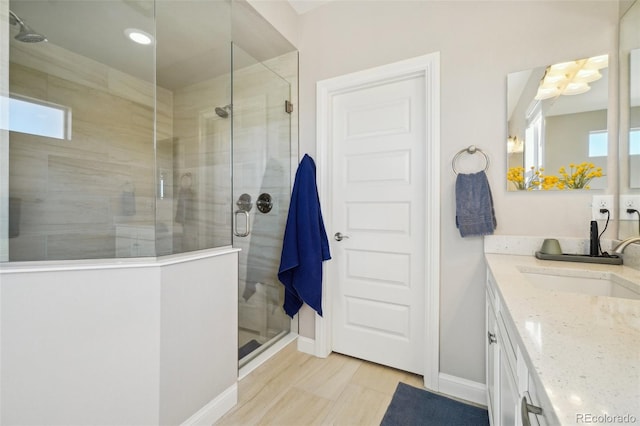 full bathroom with vanity, baseboards, and a stall shower