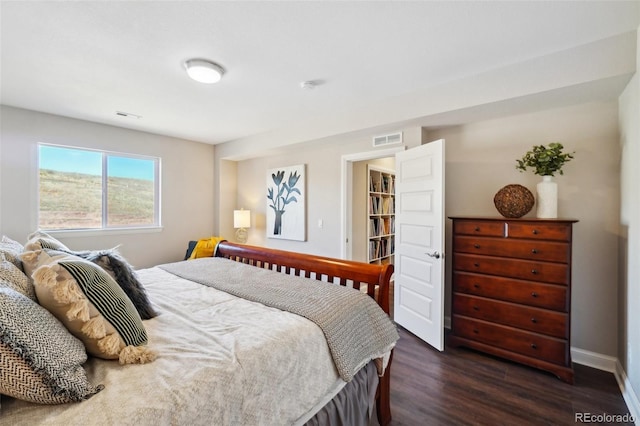 bedroom with dark wood finished floors, baseboards, and visible vents