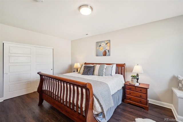 bedroom with a closet, baseboards, and wood finished floors